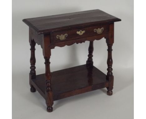 A 17th century style joined oak occasional table the rectangular top with moulded edge over a single frieze drawer and scroll