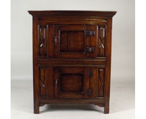 An 18th century oak food hutch, the moulded cornice over two central single panel doors fitted with iron butterfly hinges and