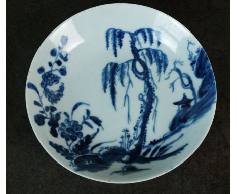 A Worcester saucer, circa 1760, painted in blue with the Landslip pattern, with a hut on a hillside amongst trees and floweri