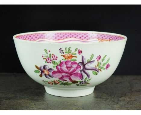 A Caughley polychrome tea bowl, circa 1785-90, painted with flowers, below a red line and purple border, unmarked, 8cm diamet