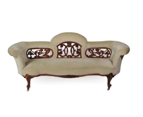 A Victorian Carved Walnut Three-Seater Sofa, circa 1870, recovered in button velvet with a pierced and scrolled back support,