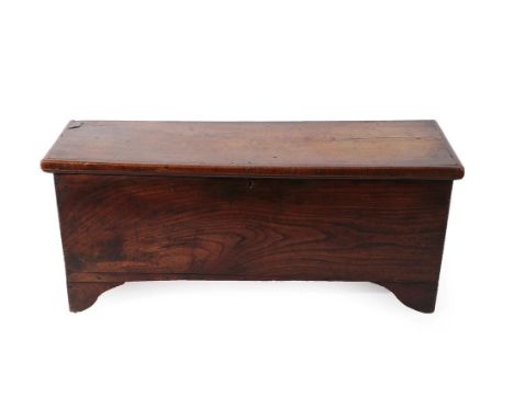 A 17th Century Elm Sword Chest, of six plank construction, the hinged lid enclosing a candle box, the front panel with a chip