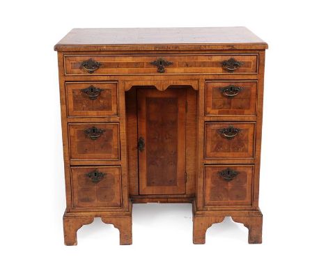 A Walnut and Oyster Veneered Kneehole Dressing Table, in George I style, the crossbanded moulded top above a long frieze draw