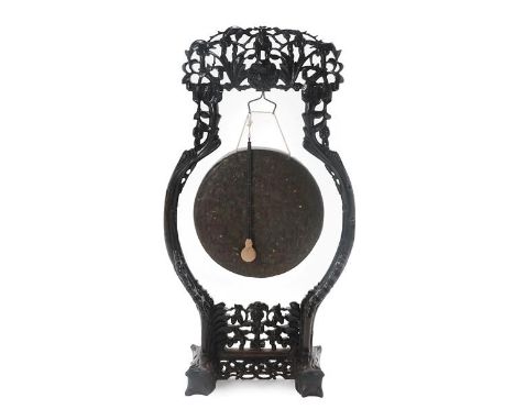 A Chinese Carved Hardwood Dinner Gong, late 19th/early 20th century, the foliate carved frame centred by a dragonhead suspend