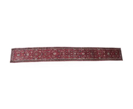 Narrow Saroukh Runner West Iran, circa 1980 The scarlet field of palmettes and scrolling vines enclosed by narrow meandering 
