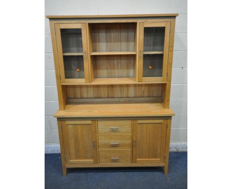 A MODERN LIGHT OAK DRESSER, the top with two glazed doors, and an arrangement of shelving, atop a base with two cupboard door