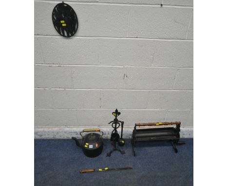 A CAST IRON NEWSPAPER LOG ROLLER, a partial companion set, a kettle, a wall plaque, a copper coal scuttle, and a handled tool