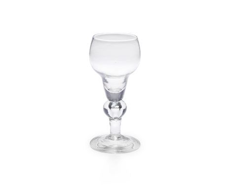 A rare baluster wine glass, circa 1710The unusual cup-shaped double ogee bowl with a solid base, on a teared inverted baluste