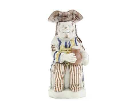 A Staffordshire pearlware Toby Jug, circa 1800Of traditional form with a foaming brown jug resting on his knee and a pipe aga