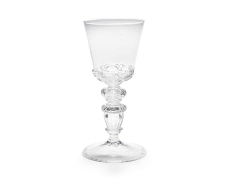 A rare and early baluster goblet, perhaps Liège, late 17th centuryIn soda glass, the generous round funnel bowl heavily mould