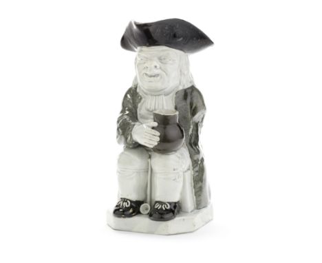 A pearlware Toby Jug, circa 1800Of traditional form, seated with a jug resting on his knee and steadied with his right hand, 