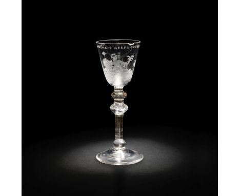 A Dutch engraved light baluster wine glass, circa 1760The round funnel bowl depicting Liberty seated on a grassy bank, holdin