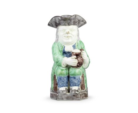 A creamware Toby Jug, circa 1785Of traditional form, seated and holding a foaming jug in both hands, a pipe held between the 