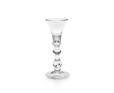 A good baluster wine or cordial glass, circa 1720The flared trumpet bowl with a deep solid base enclosing a tear, supported b