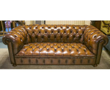 CHESTERFIELD SOFA, Victorian deep button tan leather upholstered with carved back and arms on later bun feet and castors, 200