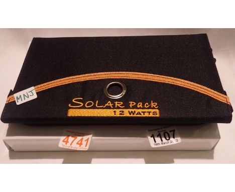 New old stock, 12 watt folding solar panel pack with two USB charging outputs. Integral part of case with magnetic catch and 