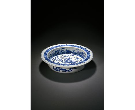 A CHINESE BLUE AND WHITE BASIN, 1ST HALF 19TH CENTURY The centre painted with a scaly dragon and a flaming pearl of wisdom am