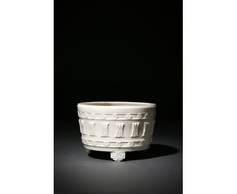 A CHINESE BLANC DE CHINE INCENSE BURNER, 18TH/19TH CENTURY The tapering body raised on three scroll feet, decorated in relief