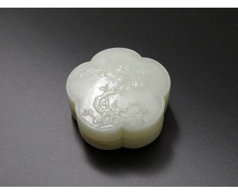 A CHINESE PALE CELADON JADE BOX AND COVER, QING DYNASTY Formed as a prunus blossom, the top carved in shallow relief with a g