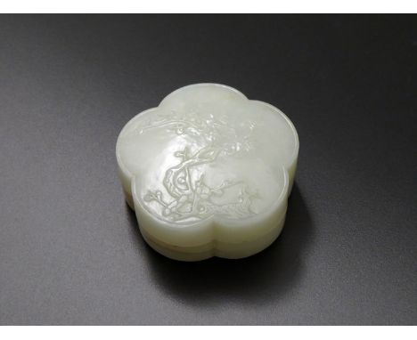 A CHINESE PALE CELADON JADE BOX AND COVER, QING DYNASTY Formed as a prunus blossom, the top carved in shallow relief with a g