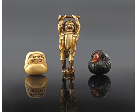 TWO JAPANESE NETSUKE MEIJI 1868-1912 Carved in ivory, one depicting a Daruma doll, unsigned, the other carved as Daruma yawni