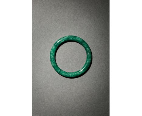 A SMALL CHINESE JADEITE BANGLE LATE QING DYNASTY The stone of a rich green tone with darker markings, 6.7cm Please note the s