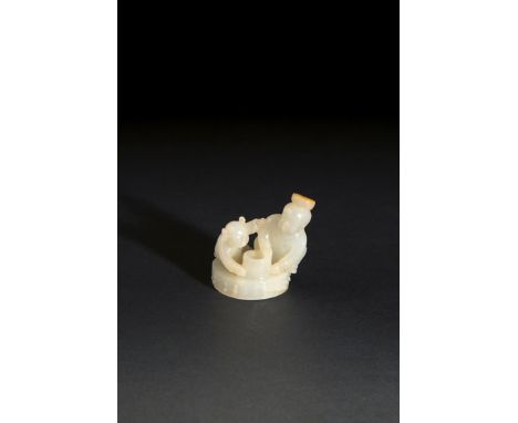 A SMALL CHINESE PALE CELADON JADE CARVING OF A MAN WITH A BOY, QING DYNASTY OR LATER Crouching together on a circular platfor