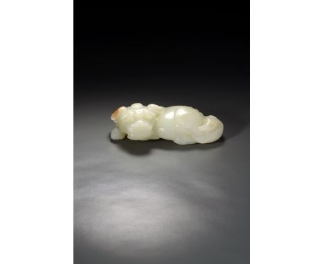 A CHINESE PALE CELADON JADE MODEL OF A BUDDHIST LION DOG, 18TH CENTURY In a recumbent position, with a bushy tail, the ears f