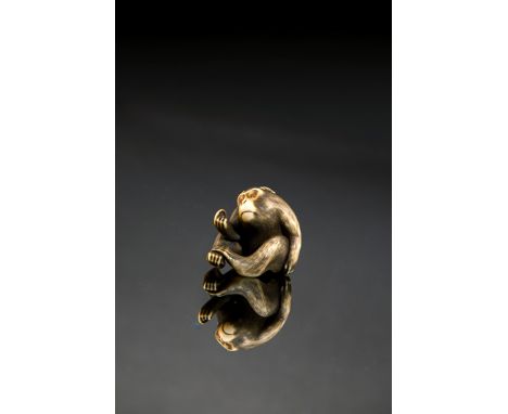 A JAPANESE IVORY NETSUKE MEIJI 1868-1912 Carved as a monkey examining a flea between his fingers, his other hand scratching h