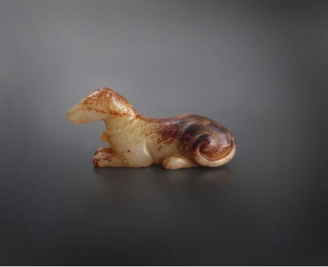 A CHINESE CELADON JADE CARVING OF A HOUND, POSSIBLY SONG DYNASTY In a reclining posture, with its ears flattened to its body 