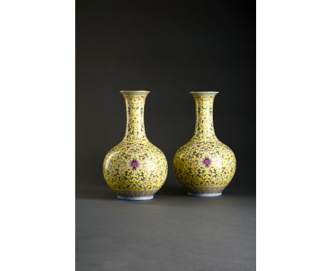 A PAIR OF CHINESE FAMILLE ROSE BOTTLE VASES, 19TH CENTURY Each decorated with a stylized lotus scroll, with peaches, other fl