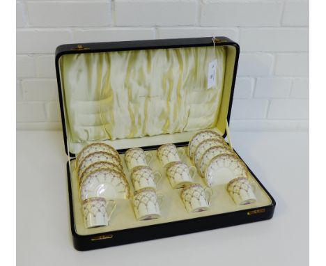 A Royal Worcester porcelain cabaret set in fitted case, painted with lilac floral sprays with gilt rimmed borders, in a velve