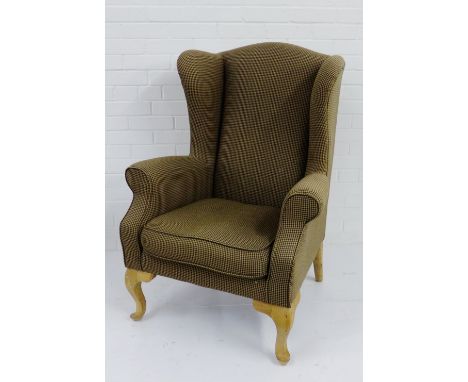 An upholstered chequered  wing back armchair on light wood cabriole supports, 112 x 83cm 