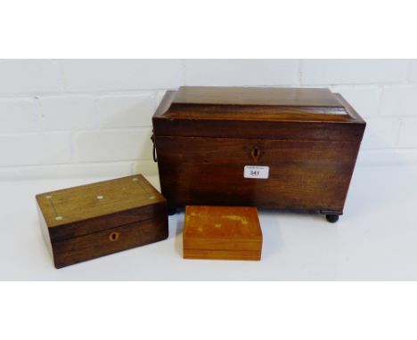 A 19th century mahogany sarcophagus shaped tea caddy, the hinged lid opening to reveal a fitted interior on four bun feet wit