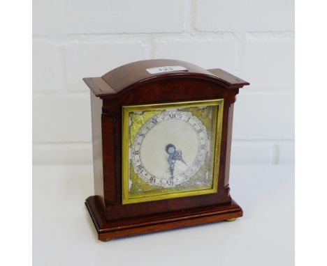 An Elliot of London mantle clock in a burr wood case and on four brass bun feet, 17cm high