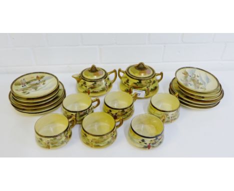 A Japanese earthenware Satsuma teaset painted with female figures in a landscape setting, comprising six cups, six saucers, s