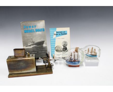 Two model ships in bottles, together with a model boat steam engine and the books 'Secrets of Ships in Bottles' and 'Power Mo