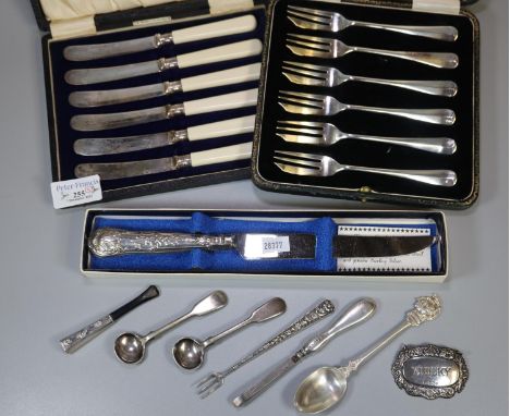 Collection of assorted silver and silver mounted items to include: pickle fork, tweezers, teaspoon, decanter label, two salt 