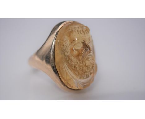 A carved citrine ring with a relief classical portrait set in a yellow metal setting with D-shape shank. The oval cabochon ci