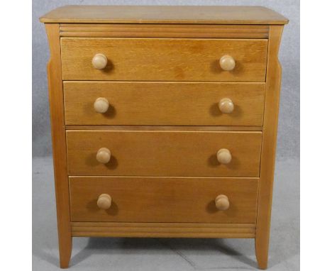 A mid century light oak chest of drawers on splay supports with maker's label to the inside. H.90 W.79 D.42cm 