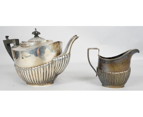 An Edwardian gadrooned silver tea pot and matching milk jug, with ebony finial and handle. Hallmarked: WBltd for Williams (Bi