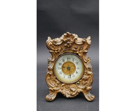 An antique gilt metal carriage clock by The British United Clock Company Birmingham and France. The clock has a relief floral