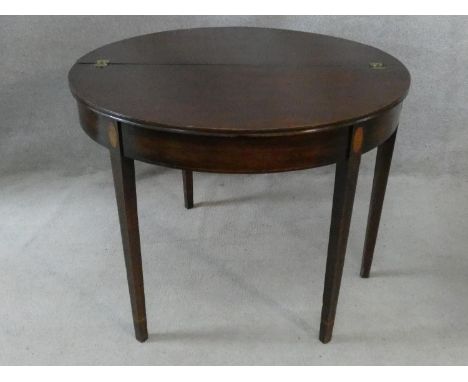 A Georgian mahogany and satinwood inlaid demi lune console tea table with foldover top and gateleg action on square tapering 