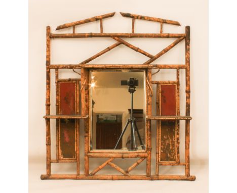 An early 20th century bamboo framed mirror - with peaked top, upper central shelf and two smaller side shelves, 84cm wide, 98
