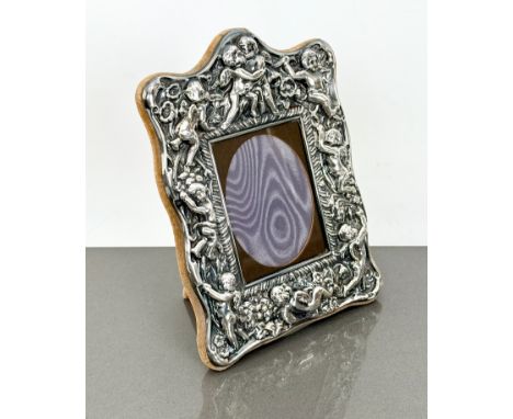 An ornate silver plated easel picture frame - by Carrs of Sheffield, decorated with cherubs, 20 x 14cm.