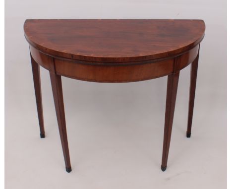 A George III mahogany demi lune card table - the cross banded top with later circular green baize (in good condition), raised