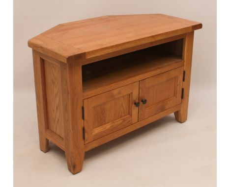 A blonde oak tv cabinet - hexagonal top over an open shelf and panelled cupboard doors. (LWH 93.5 x 50 x 64cm)