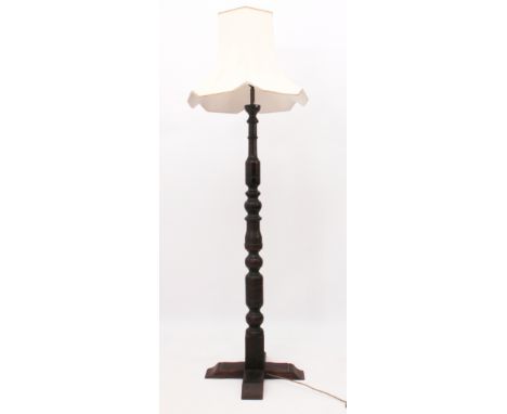 A turned oak standard lamp - fourth quarter 20th century, with cross shaped base and cream fabric shade, 130cm high plus fitt