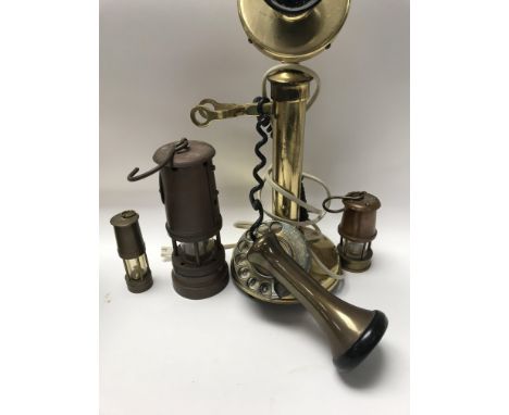 A brass stick telephone and three lamps .