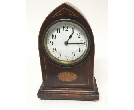 An Edwardian inlaid mahogany clock with an arch shaped vase a d white enamel dial